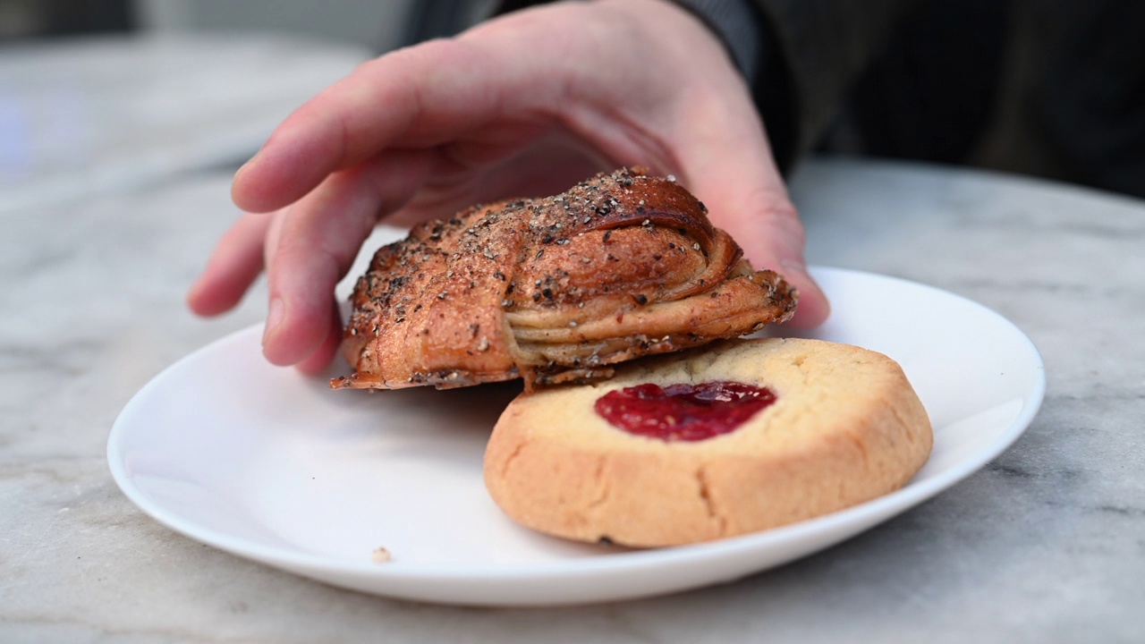 人拿起肉桂面包从咖啡盘瑞典酥饼饼干视频素材
