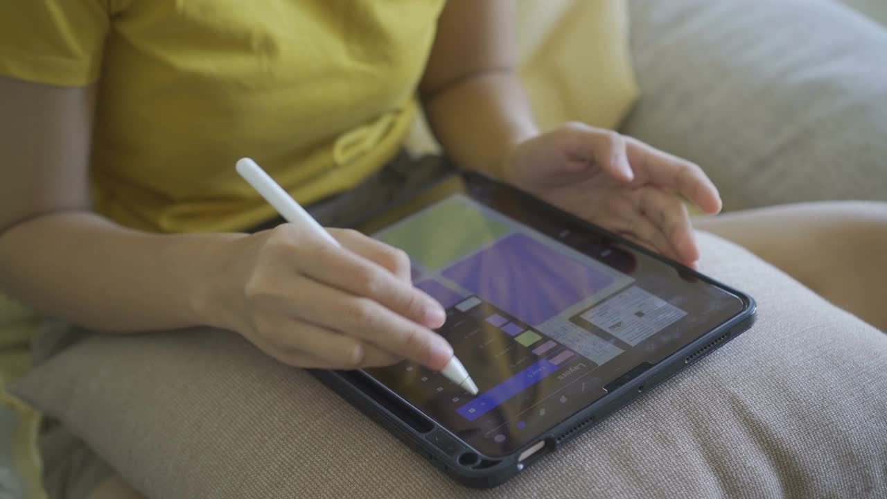 一个亚洲女人准备做手工工作，她正在用她的iPad设计。视频下载