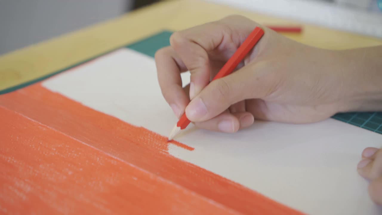 一个女人的手正在纸上画红色。视频下载