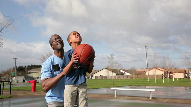 父亲抱起儿子去打篮球视频素材
