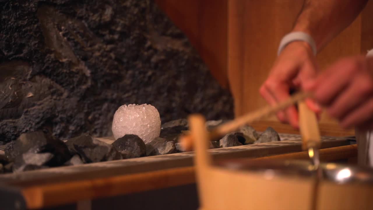 桑拿房，女性用盐砖把水倒进热石头里视频下载
