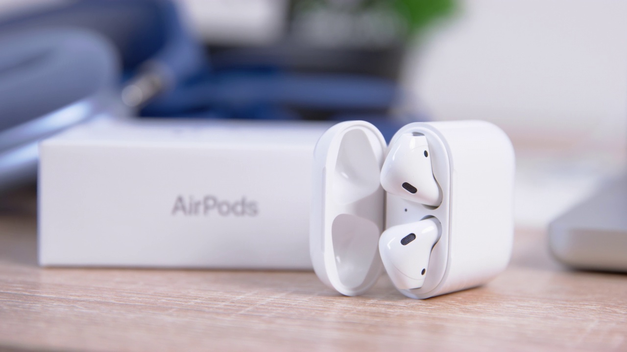 时尚的苹果Airpods躺在光滑的箱子里，靠近笔记本电脑和白色盒子。视频下载