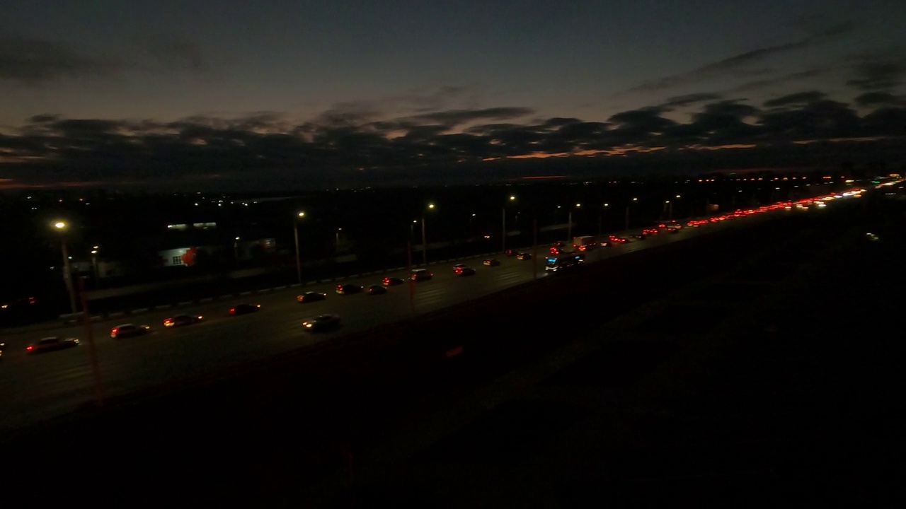 车辆行驶在夜间城市停车场附近的高速公路上视频素材
