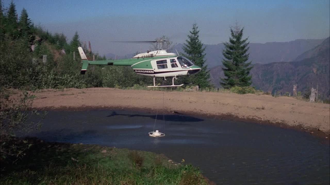 MS TS消防直升机，水桶悬挂在下方，将桶浸入小湖中视频素材