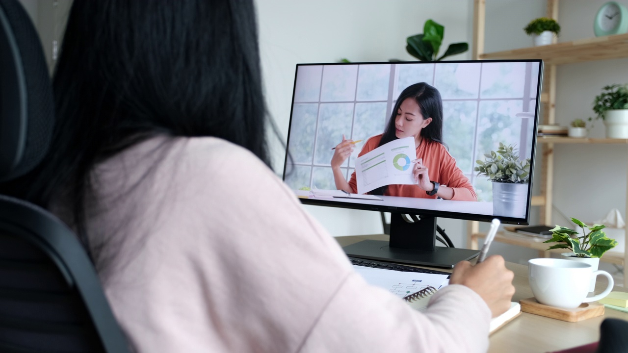 亚洲女商人在视频会议上谈论销售报告。亚洲女性和团队使用电脑进行视频电话在线会议，在家工作视频素材
