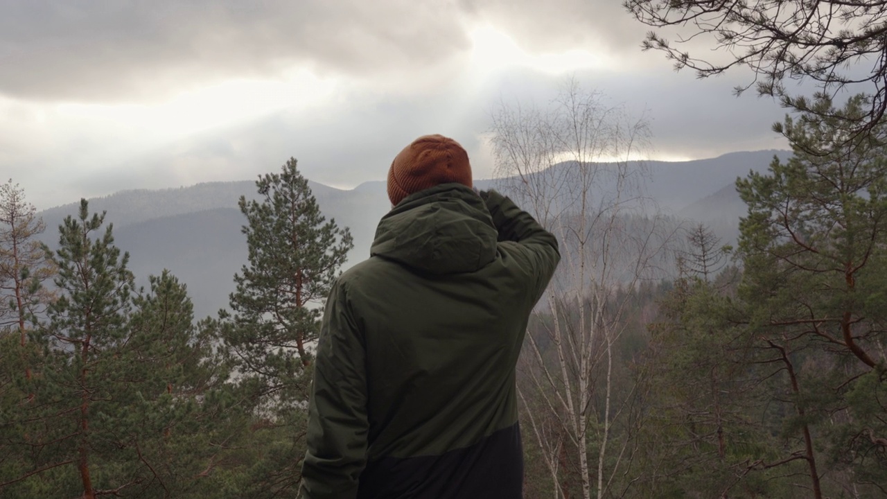 年轻人在山顶欣赏山谷的美景视频下载