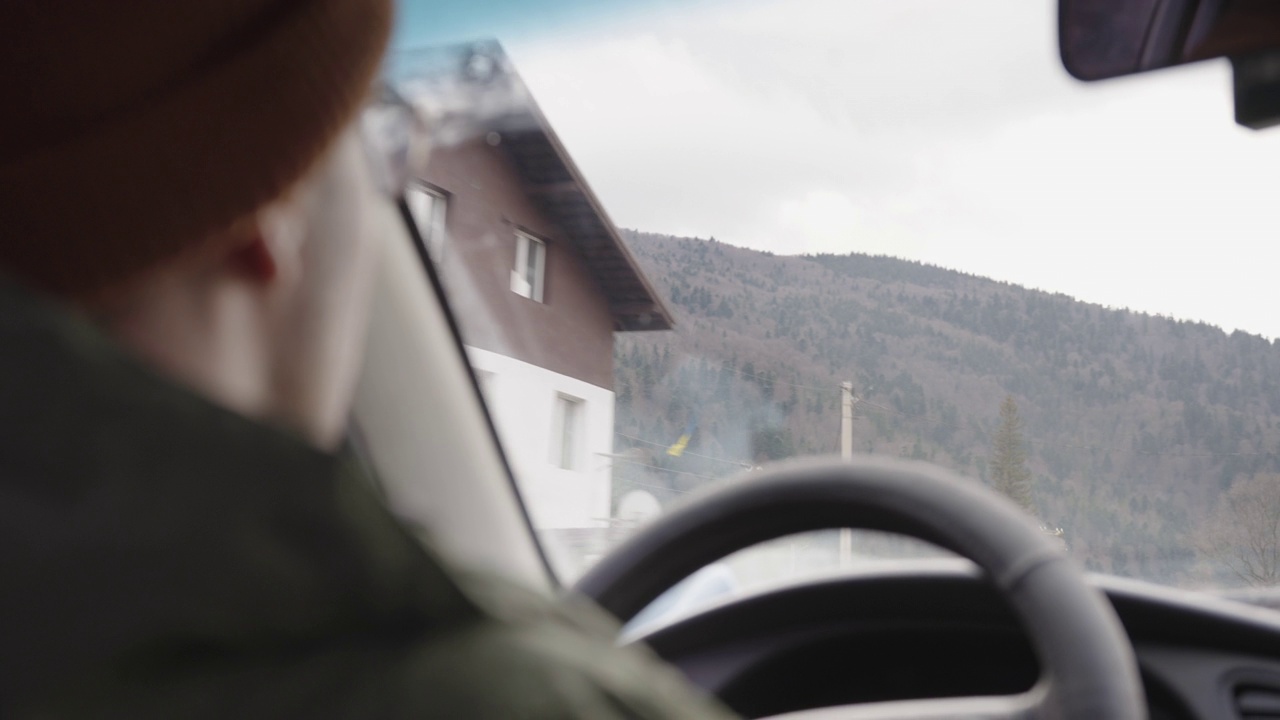 一个年轻人在山间开着车。有选择性的重点。开车旅行。视频下载