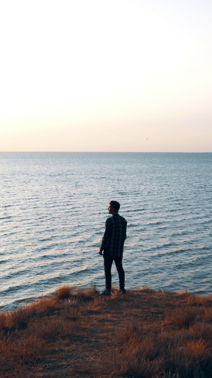 男人站在海边的悬崖上视频下载