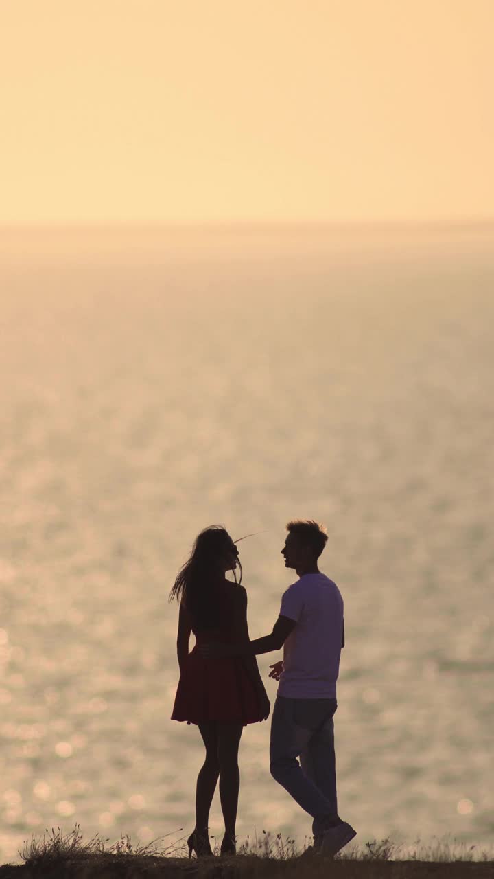 浪漫的情侣站在美丽的海景背景上视频下载
