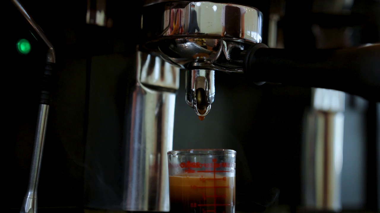 4K，咖啡滴出蒸馏器的特写镜头，将咖啡渣蒸馏成细咖啡粉，将咖啡粉蒸馏到杯中成为水。视频素材