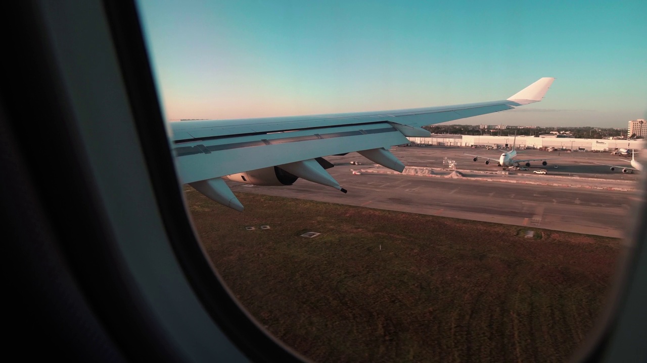 透过飞机窗户看天空和云层。在迈阿密国际机场降落。视频素材