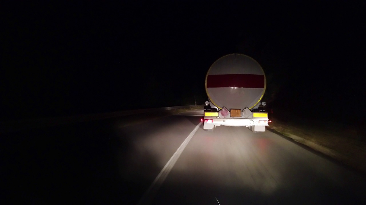 一辆卡车载着一箱可燃燃料在夜间行驶在高速公路上视频下载