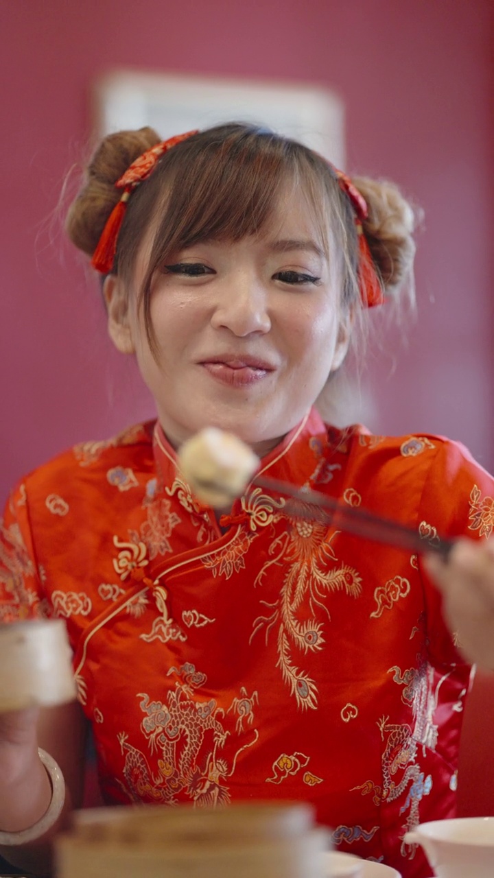 货架上的中国女人用筷子夹起一块点心，微笑着吃着视频下载