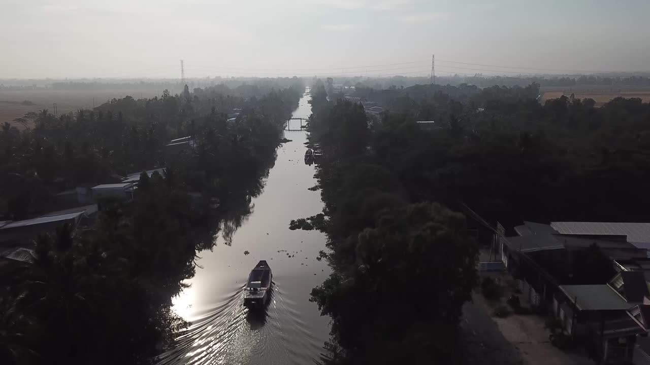 Aerial view of Mekong delta cargo boat on the narrow rivers canals that meaner and crisscross Sóc Trăng  province in the Mekong Delta. South Vietnam.视频下载