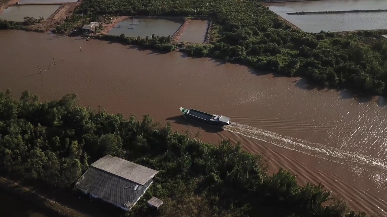 Aerial view of Mekong delta cargo boat on the narrow rivers canals that meaner and crisscross Sóc Trăng  province in the Mekong Delta. South Vietnam.视频下载