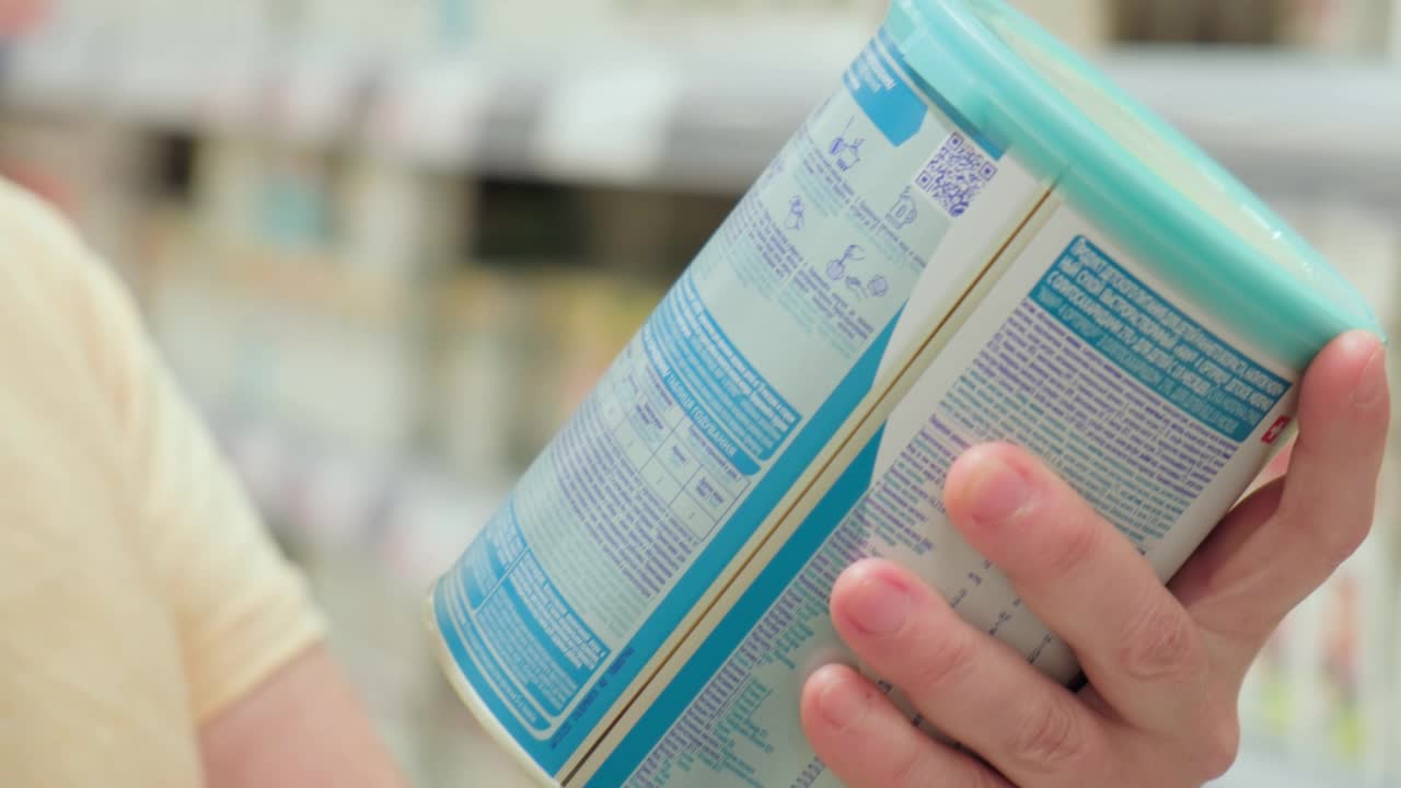 在超市里，女人用放大镜看商品罐头上的标签视频下载