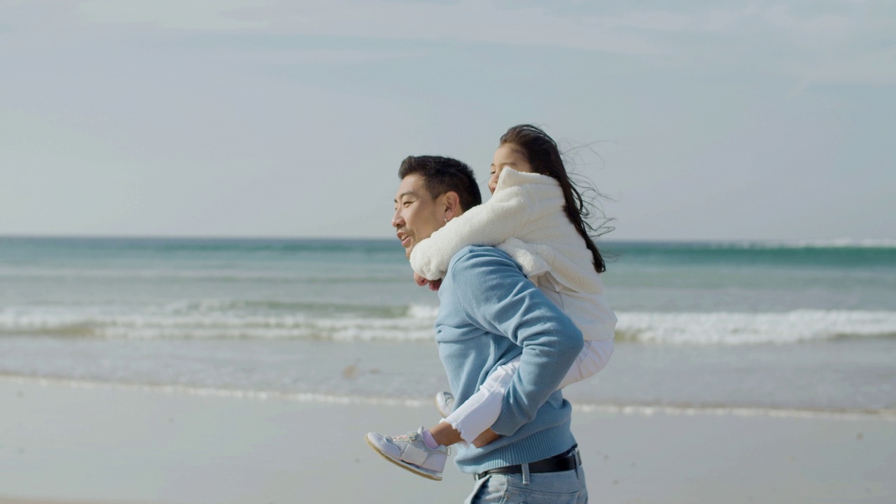 亚洲父亲和可爱的小女儿在海边散步视频下载