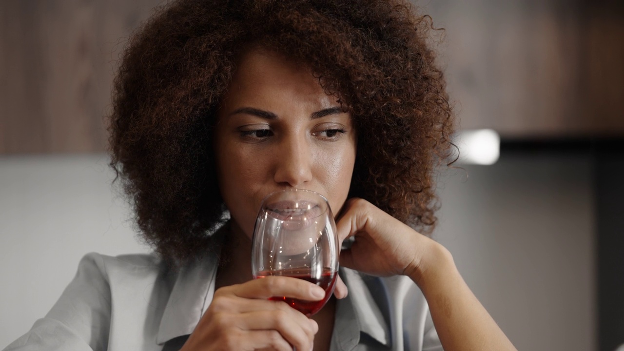 快乐的女人独自享受在家的时光，喝一杯红酒，休息视频素材