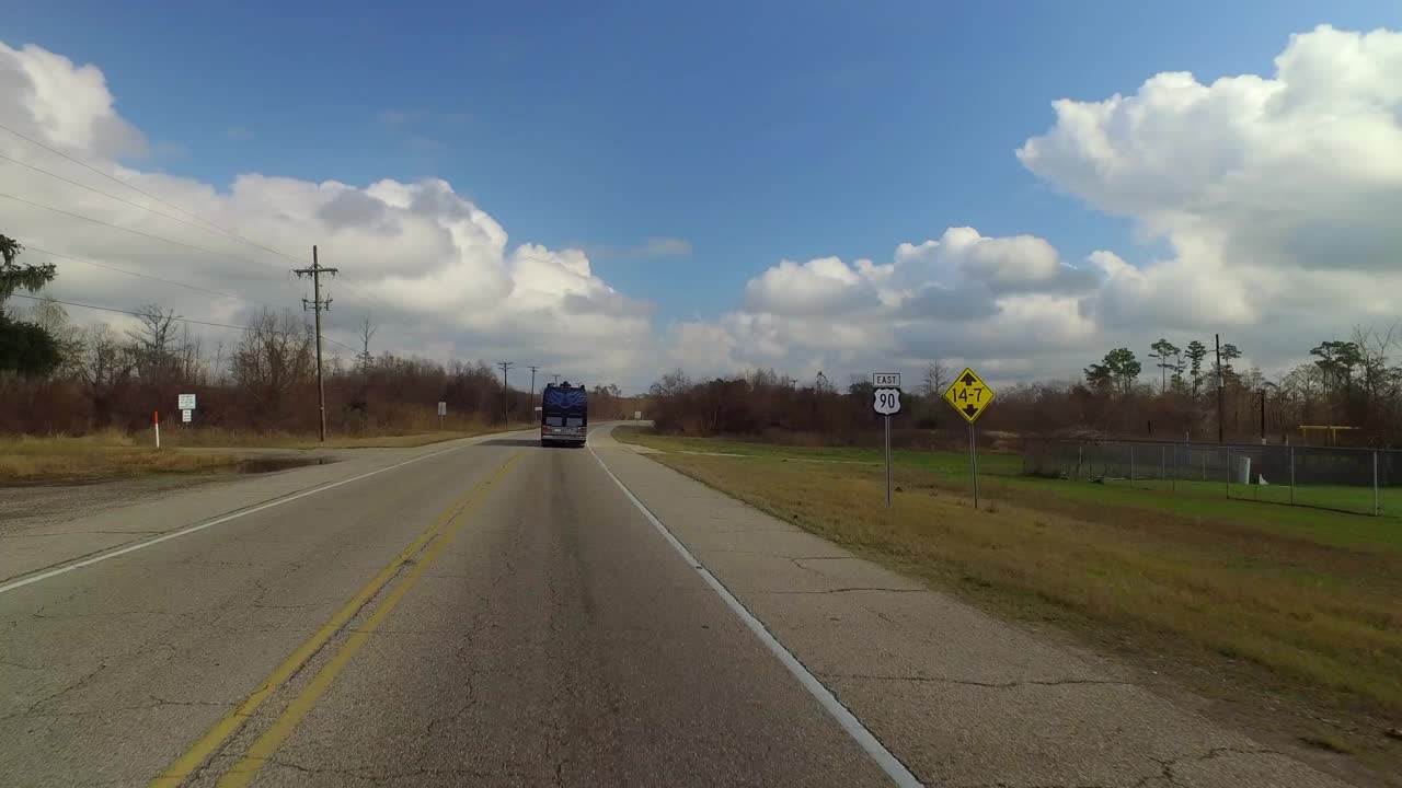在多云的天空下，大型商业巴士在光秃秃的树木中行驶-路易斯安那州新奥尔良视频下载