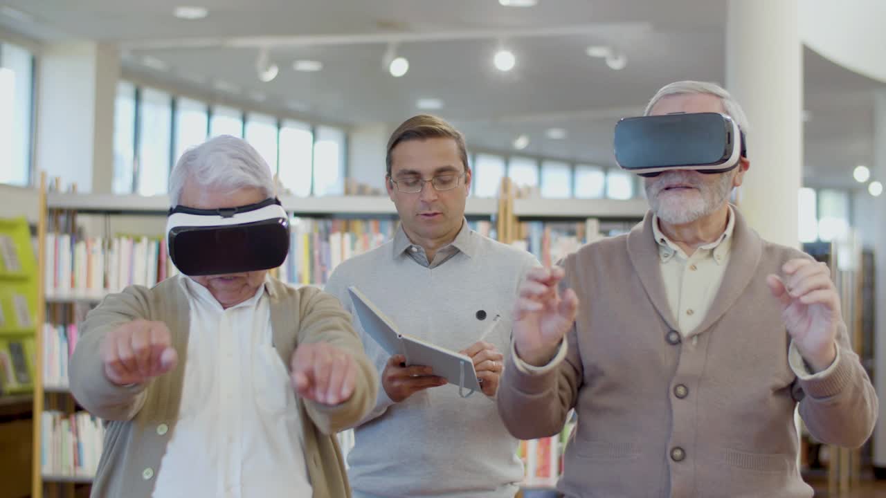 高年级男生在图书馆与老师一起使用虚拟现实眼镜视频下载