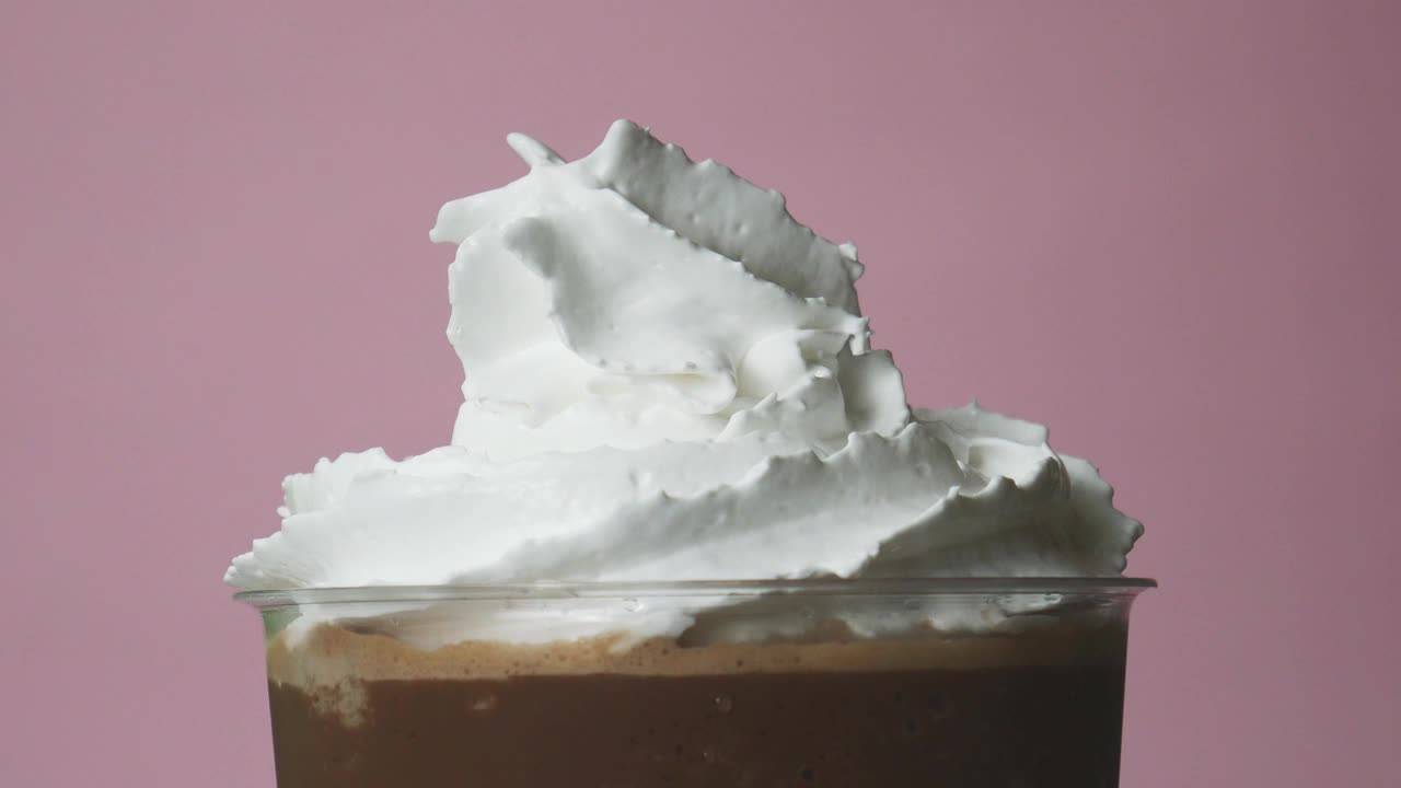 ฺBlender glass with whipped cream on top and chocolate sauce.视频下载