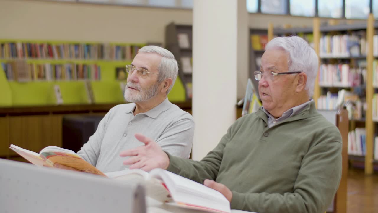 成熟的男人在图书馆边上课边聊天视频素材