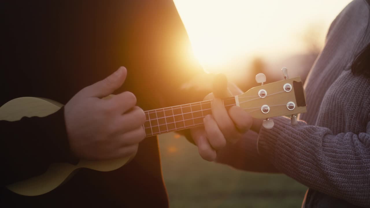 男朋友在日落时弹奏四弦琴视频下载