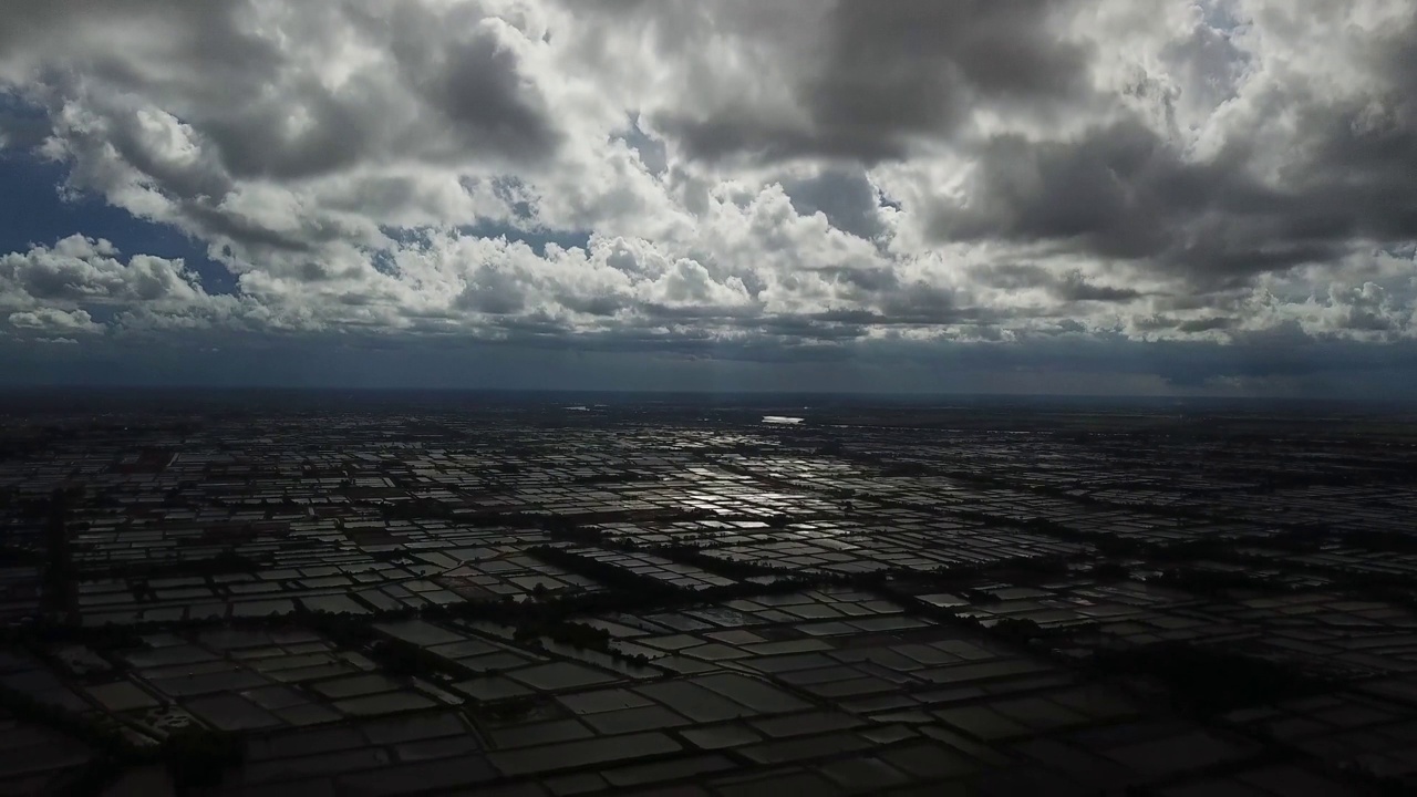 Aerial views of aquaculture farming in the Mekong Delta.  Sóc Trăng  province, Shrimp Ponds, Fish farms, set against beautiful skies and clouds and dappled sunlight. South Vietnam.视频下载