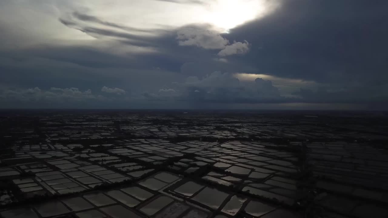 Aerial views of aquaculture farming in the Mekong Delta.  Sóc Trăng  province, Shrimp Ponds, Fish farms, set against beautiful skies and clouds and dappled sunlight. South Vietnam.视频下载