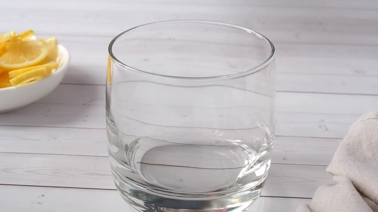 水倒进玻璃杯里。柠檬奎宁饮料的制备。视频素材