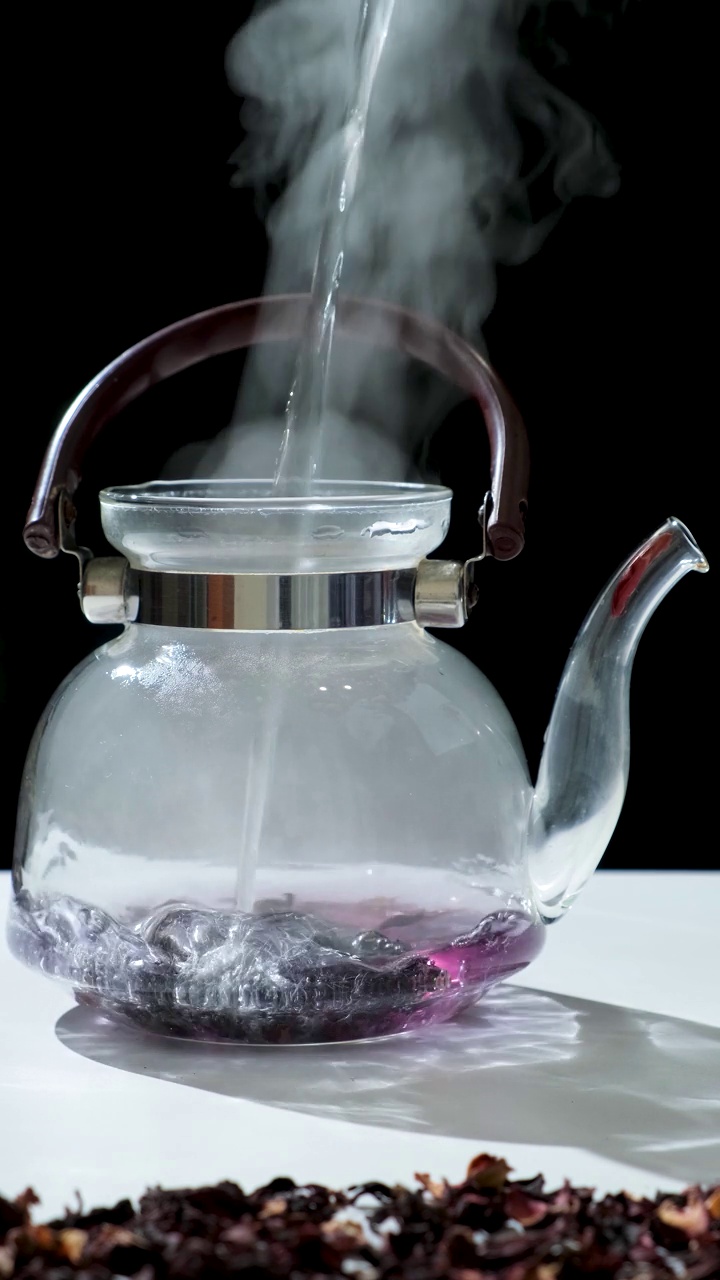 用苏丹玫瑰在玻璃茶壶中制作红木槿茶的过程视频下载