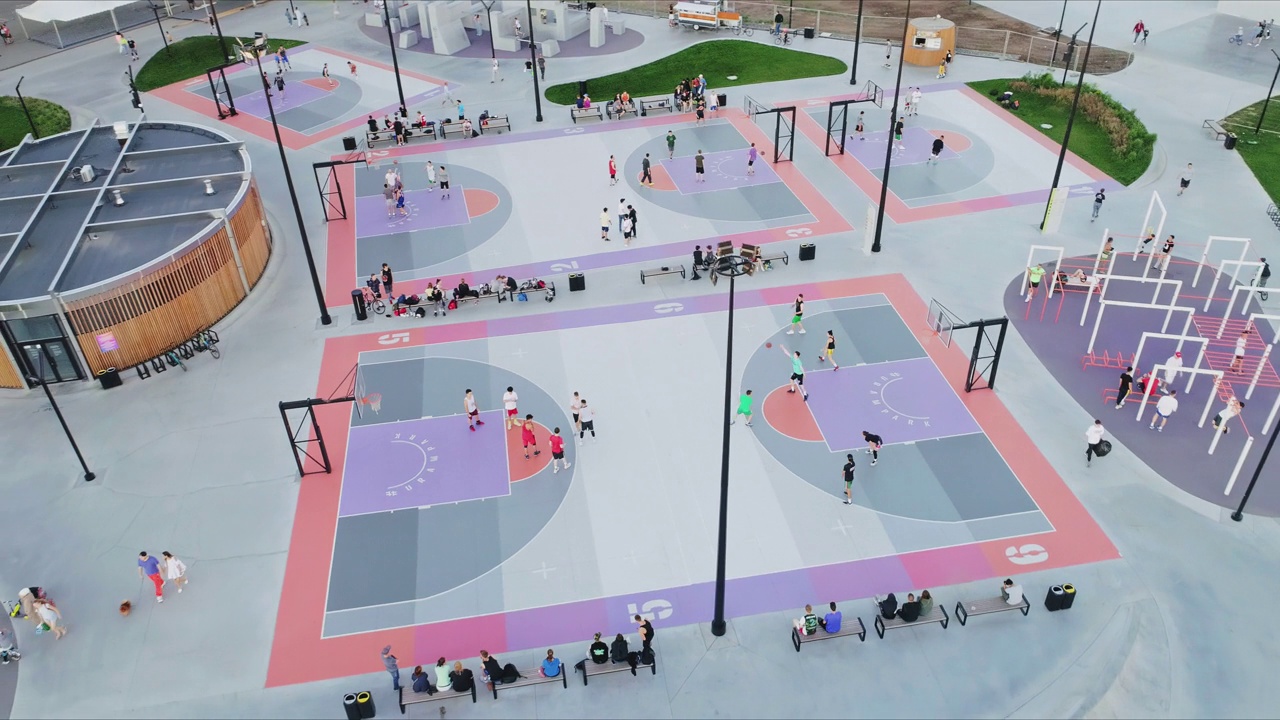 五彩缤纷的篮球场与球员在城市公园空中视频素材