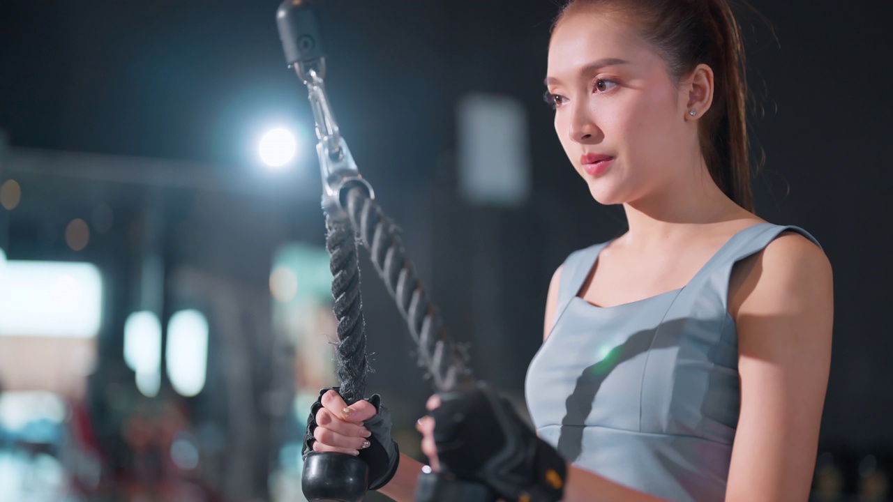亚洲女性健身运动在健身房拉下拉机。努力训练，保持健康的身体。女性在健身房使用拉下拉机健康健身和坚定的锻炼理念视频下载