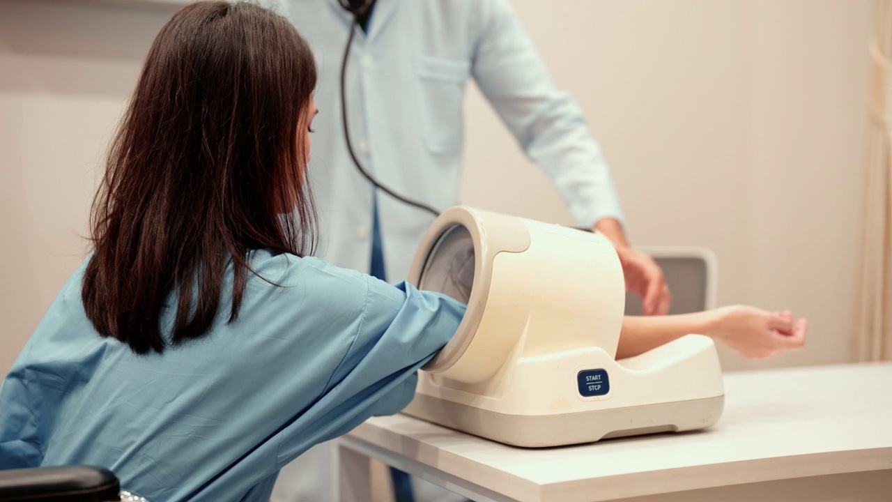白种年轻成年妇女在体检前用血压计测量血压。视频下载