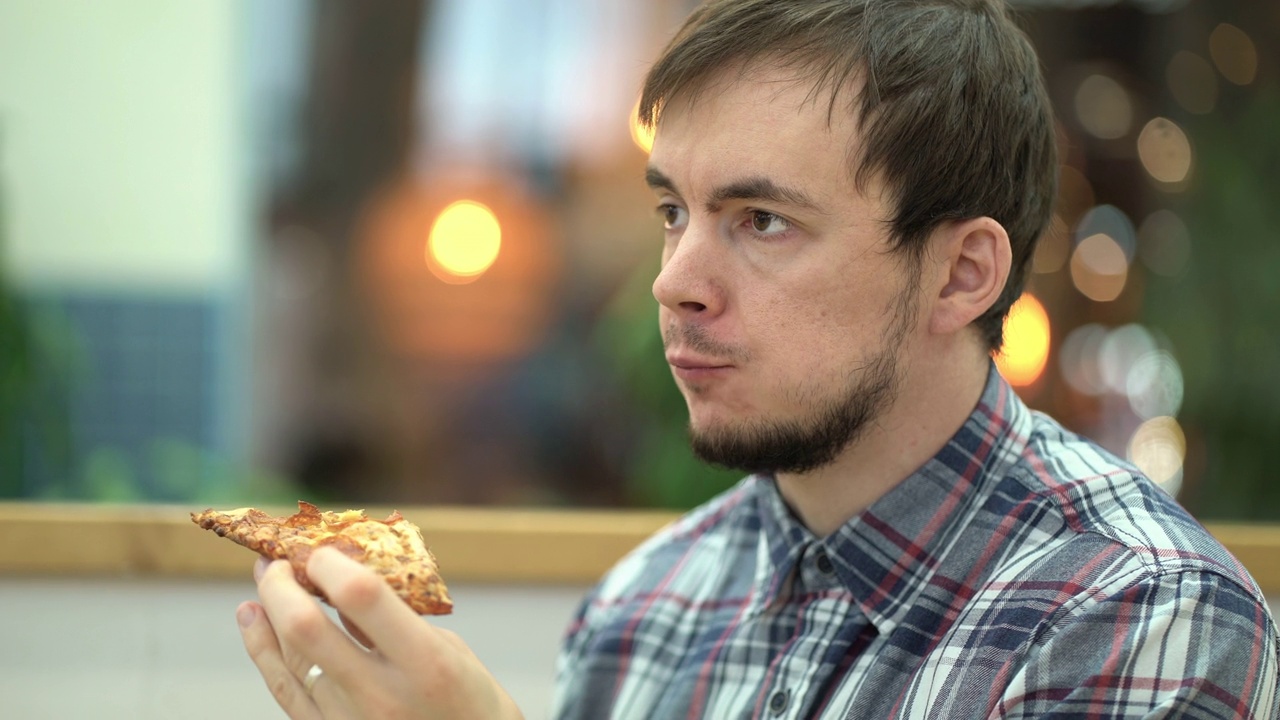 在美食广场吃披萨的疲惫男人视频下载