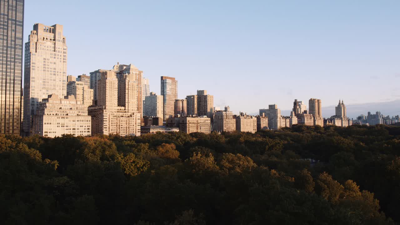 纽约市在中央公园日出的全景城市景观曼哈顿在秋季，早晨的阳光照射在城市现代建筑塔楼横跨公园，建立视图视频下载
