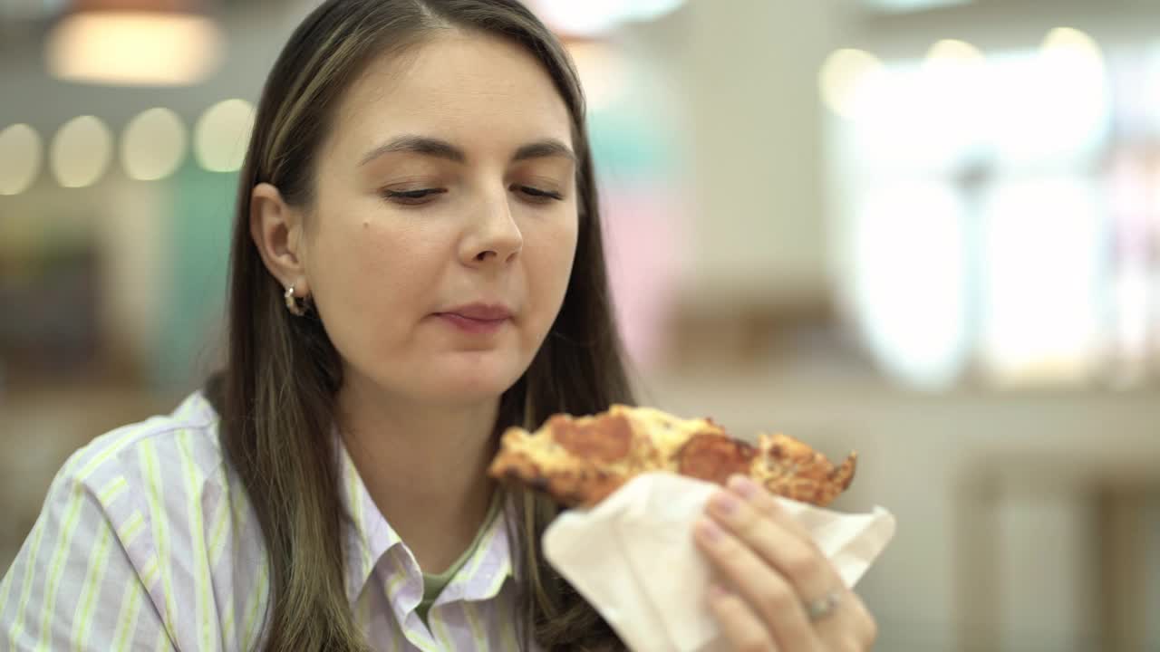 在美食广场吃辣香肠的女人。视频下载
