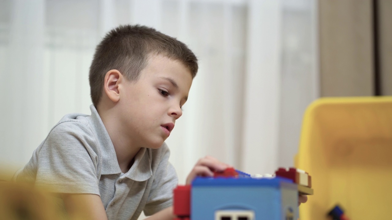 一个男孩玩积木和盖房子的特写。视频下载