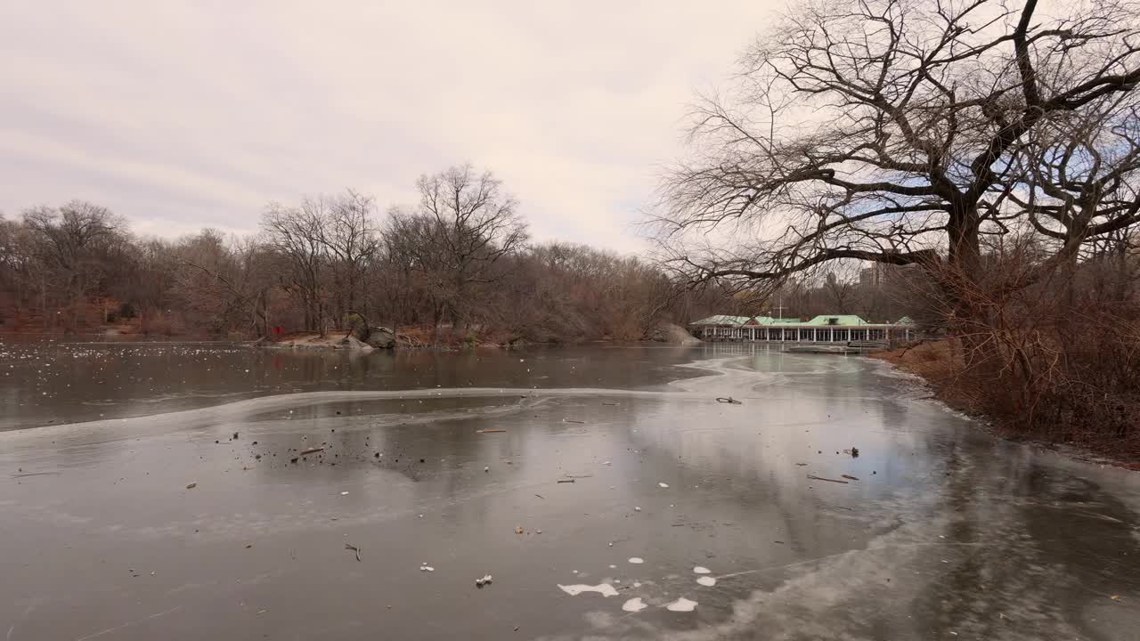 这是美国纽约市中央公园的镜头，拍摄于冬季，寒冷的冬天，湖面结冰，背景是著名的中央公园船屋。视频素材
