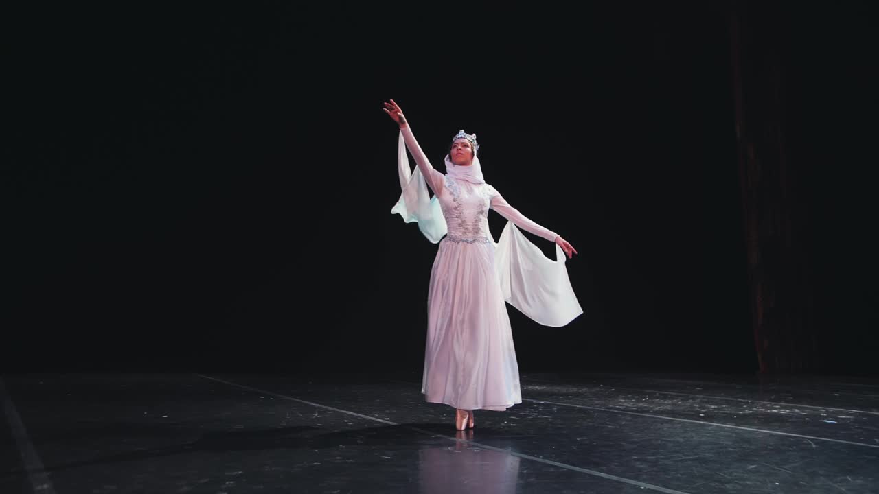 视频片段的美丽元素的经典芭蕾芭蕾舞演员跳舞在黑色背景，慢动作视频素材