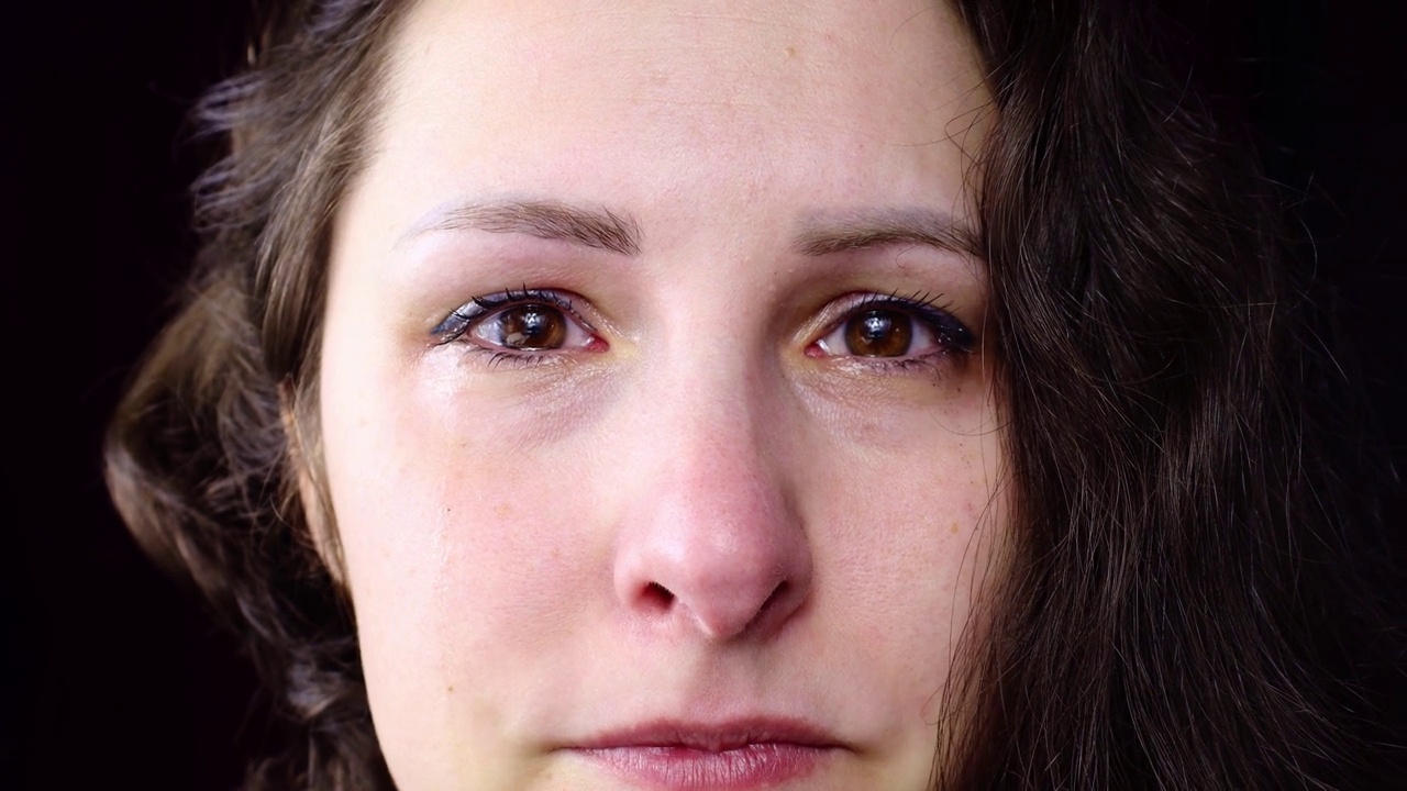 心烦意乱和沮丧的白种人黑发女子哭着用眼泪把脸拉近视频素材