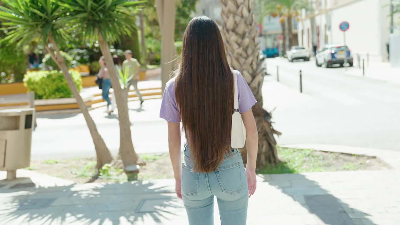 年轻美丽的西班牙女子站在街道与双臂交叉手势视频下载