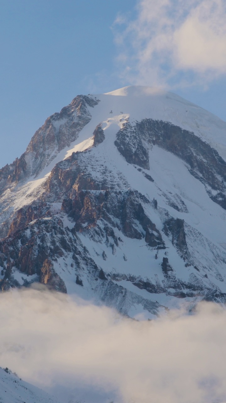 Stepantsminda, Gergeti，乔治亚州。在冬季景观中，卡兹别克峰被雪覆盖。垂直的，垂直的素材，垂直的视频视频下载