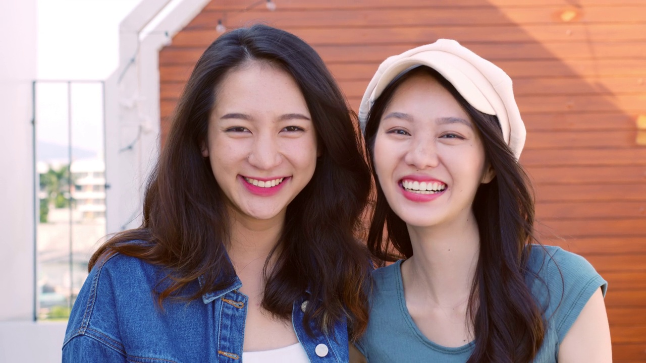 可爱的年轻亚洲女性和朋友们表达积极的情绪，微笑着对着室外的相机笑视频下载
