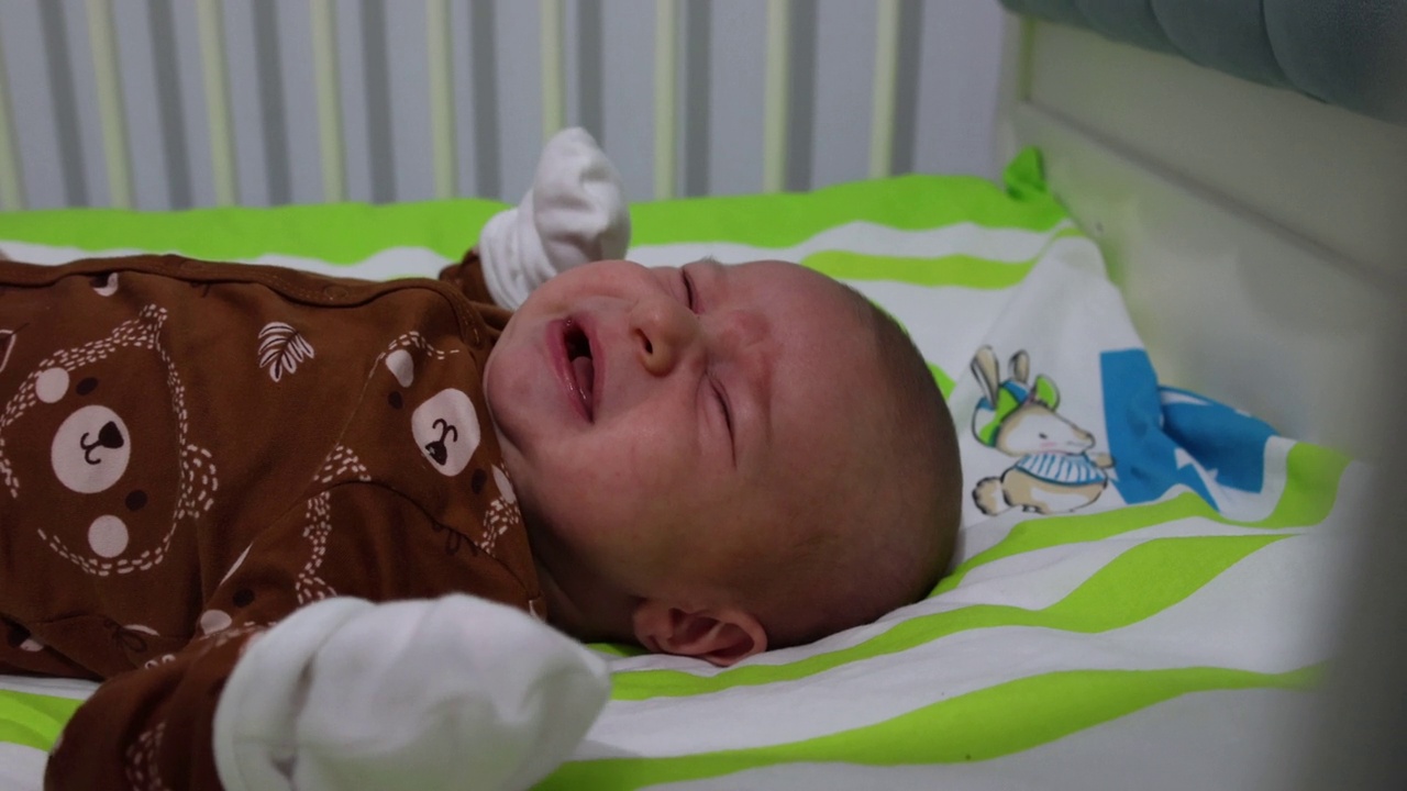 在婴儿床上哭泣的新生男婴视频下载