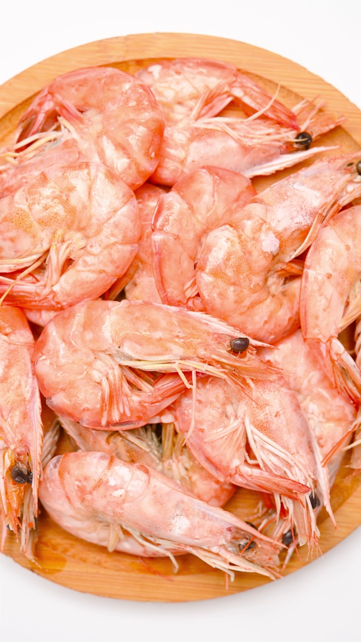 上锅将新鲜煮熟的虾仁放在白色的垂直组合上视频素材