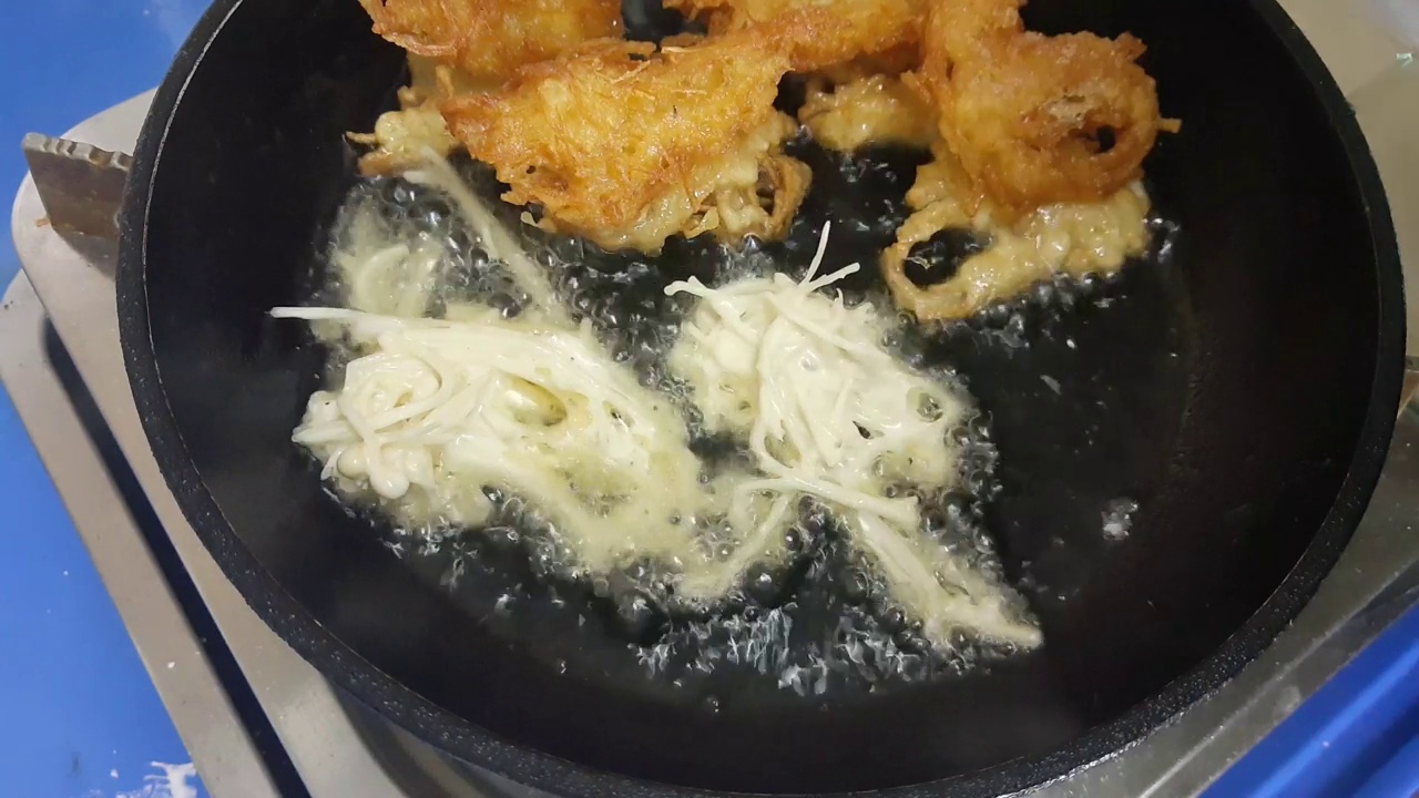 在热油中煎炸碎金针菇的镜头视频下载