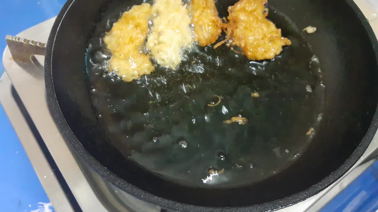 在热油中煎炸碎金针菇的镜头视频下载