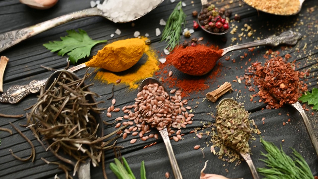 烹饪用的彩色香草和香料。印度的香料。在黑色背景上。俯视图视频下载