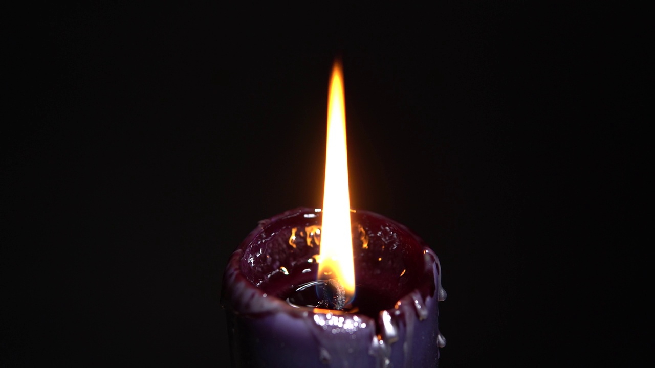 黑色魔法蜡烛与黑暗背景，选择性聚焦。神奇的万圣节恐怖概念。蜂蜡蜡烛燃烧非常快。恐怖和黑暗的情绪设置。视频素材